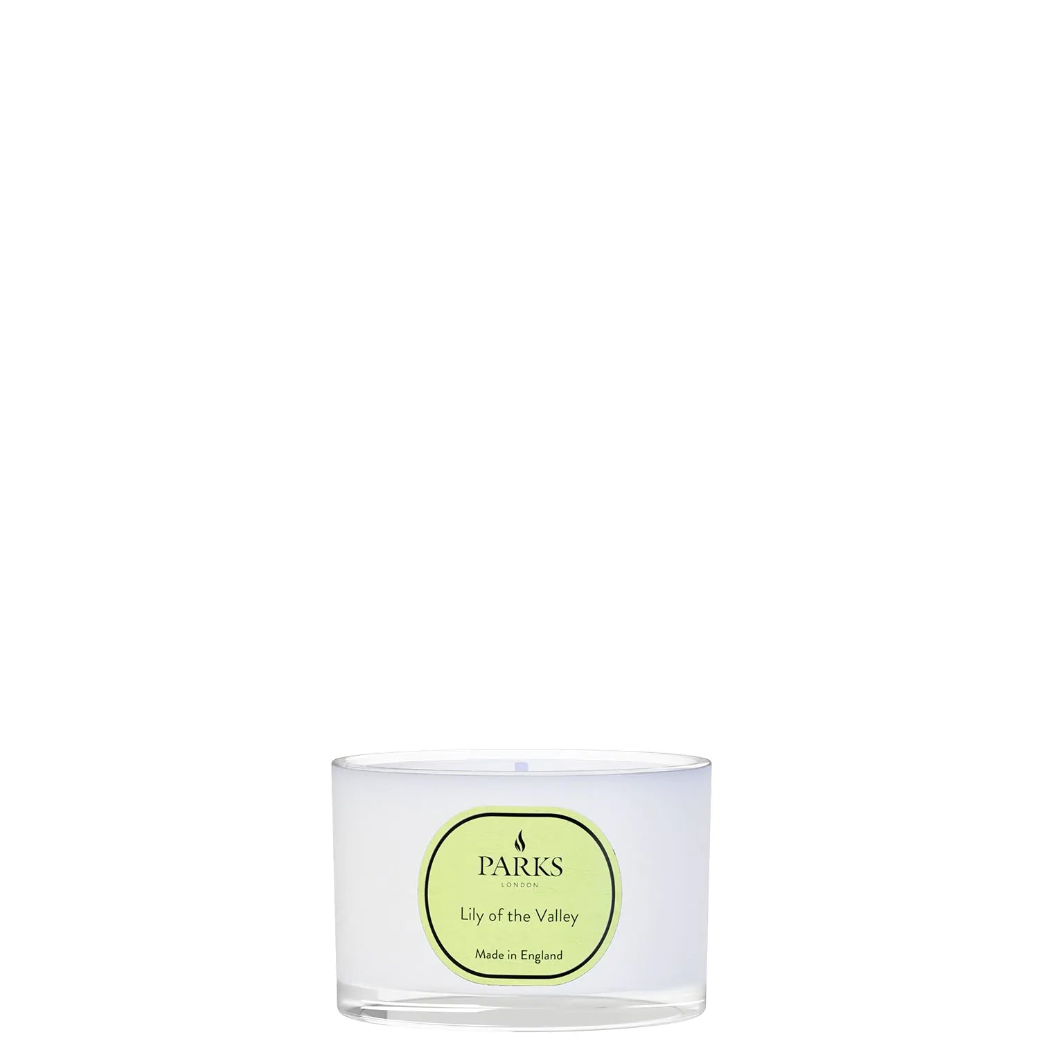 A white travel candle with a green label, titled 'LILY OF THE VALLEY', indicating the fragrance.