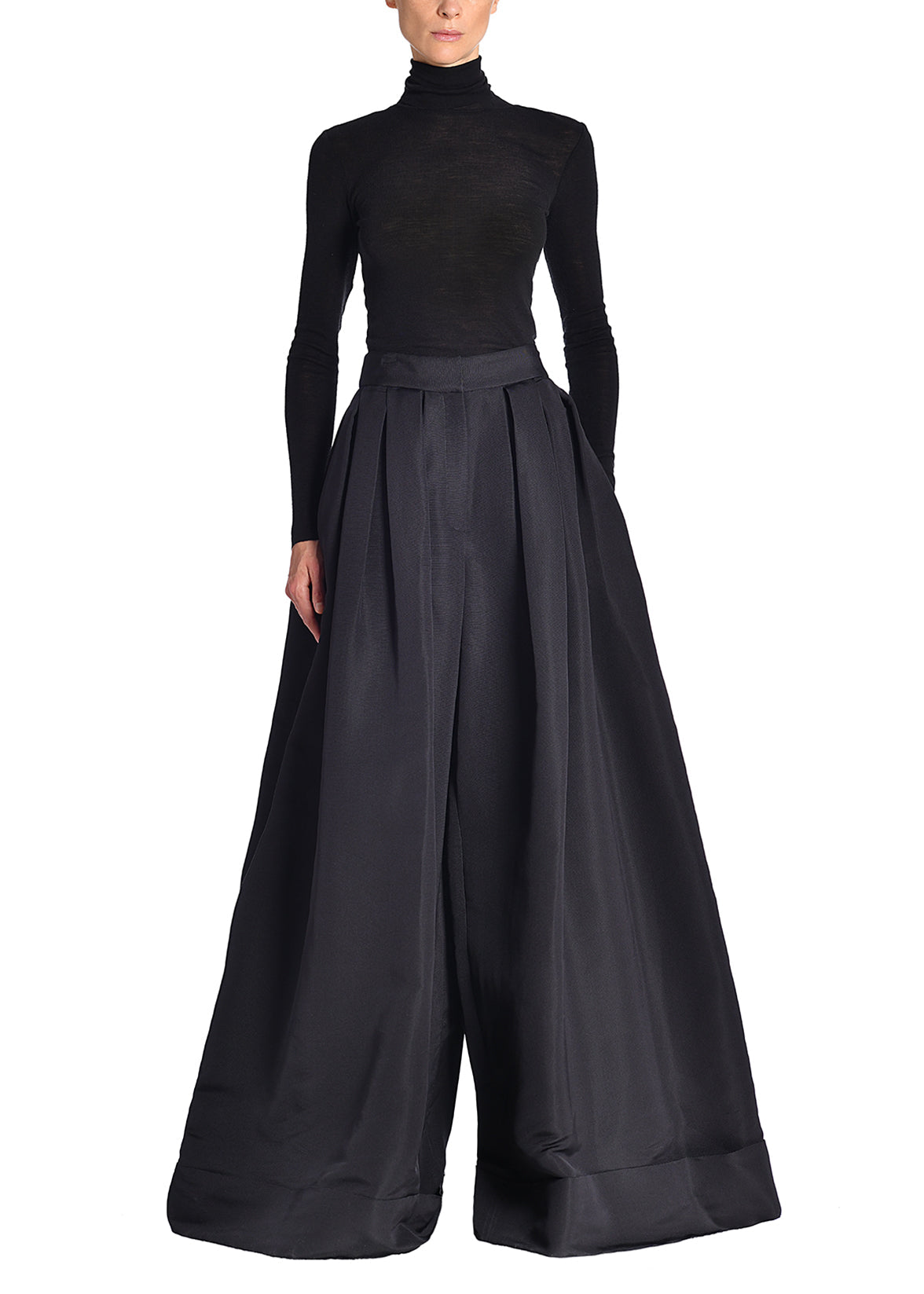 A model wearing a black turtleneck and black silk faille wide leg pants.