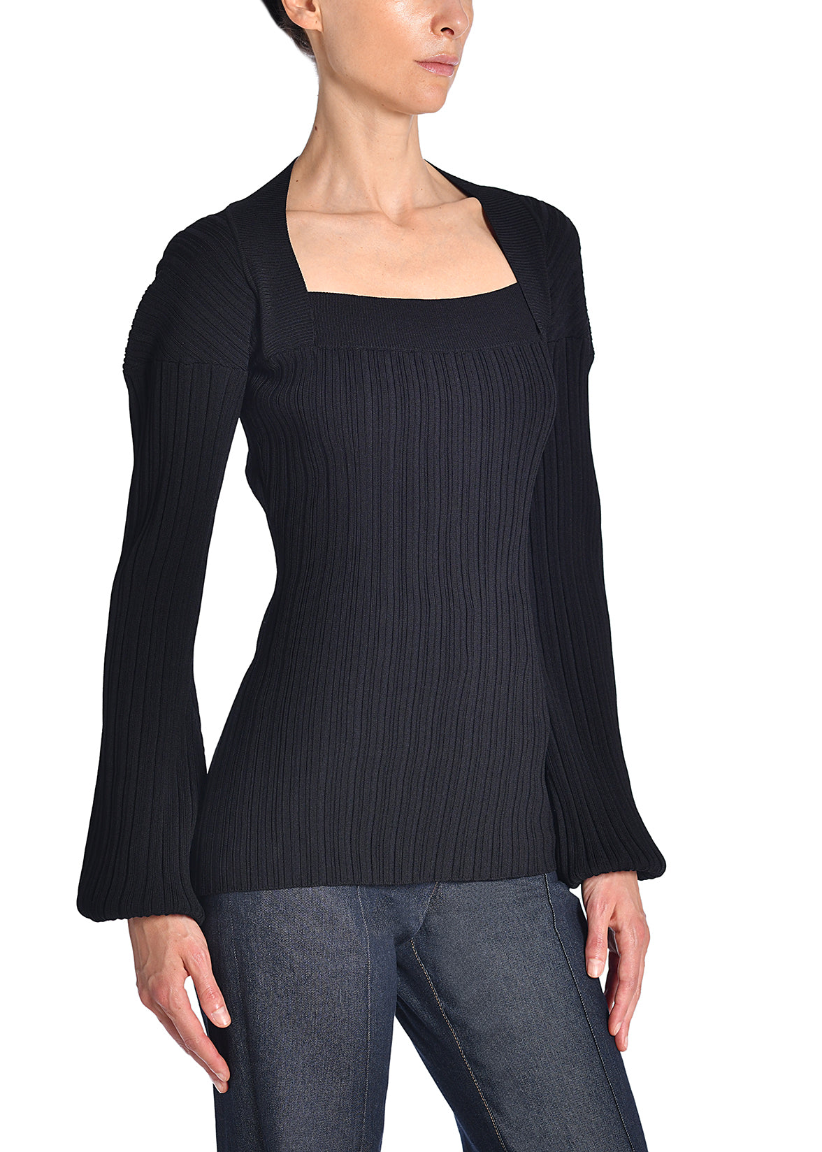 A side-facing image of a model wearing a black knit shirt