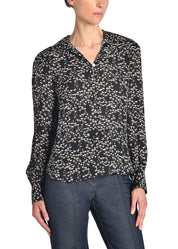 A front-facing image of a model wearing a black floral top. 