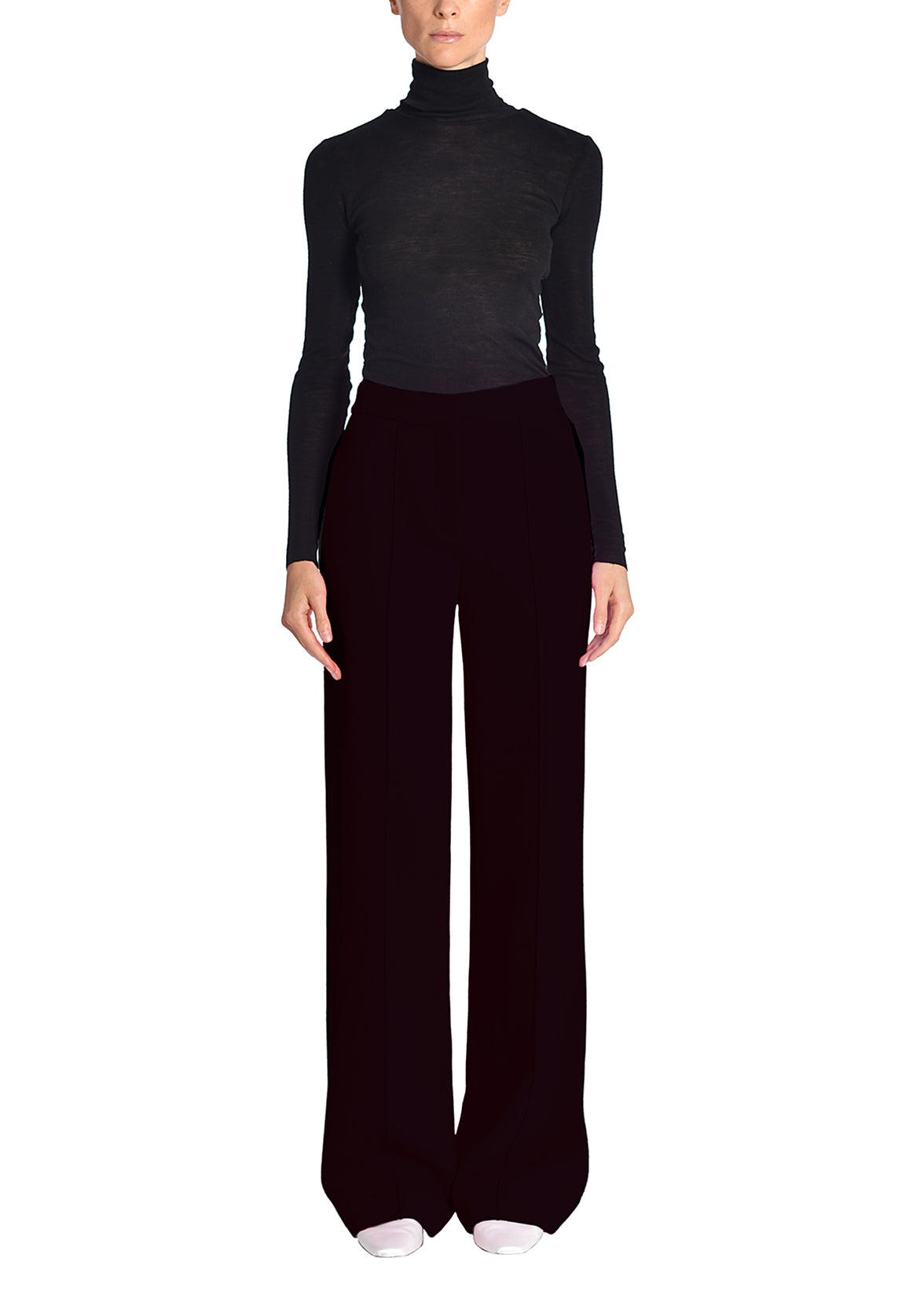 A full-length image of a model wearing a black turtleneck and black pants.