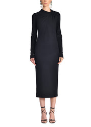 A front-facing image of a model wearing a black midi dress. 