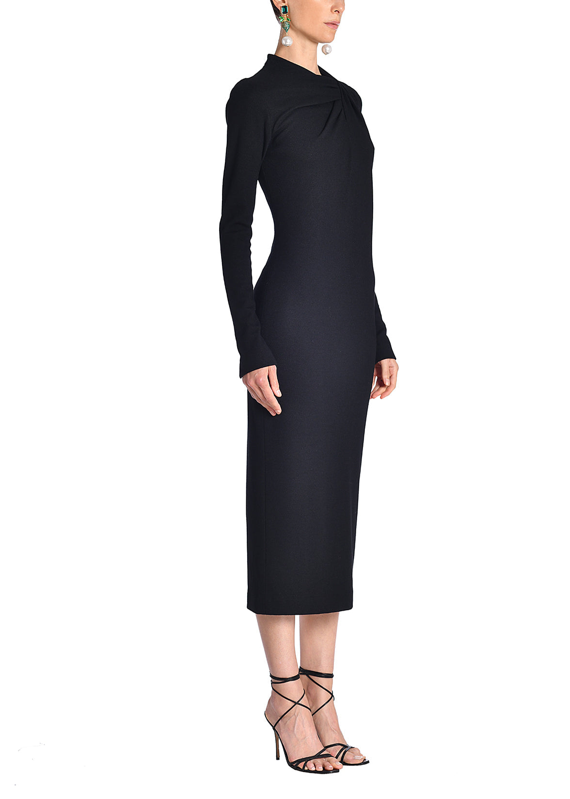 A side-facing image of a model wearing a black midi dress. 