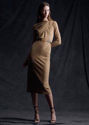 A model wearing a camel colored dress, belted at the waist with a gold fern belt.