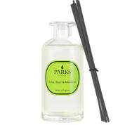 A clear glass diffuser bottle with a green label reading 'PARKS', 'Lime, Basil & Mandarin', and 'Made in England', alongside black reeds for the fragrance.