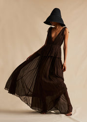 A campaign image of a model wearing a mocha brown silk gown. 