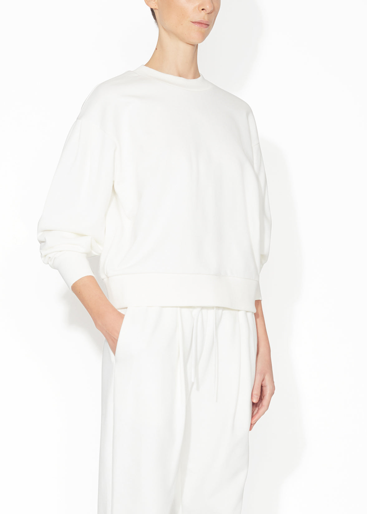 An angle view of a ivory sweatshirt.