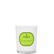 A white Parks candle with a green label that reads 'Lime, Basil & Mandarin'. The candle is in an elegant glass vessel.