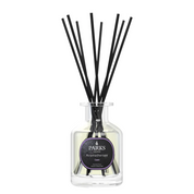 A clear glass diffuser bottle with a black label and a set of black reeds, filled with a liquid.