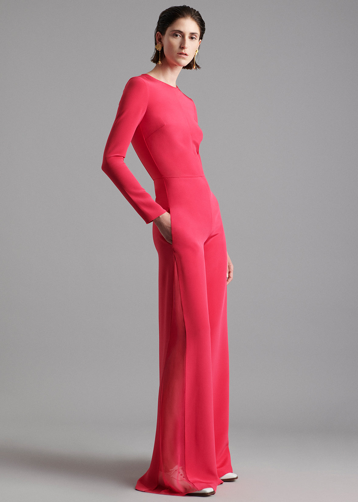 A model wearing a pink jumsuit.